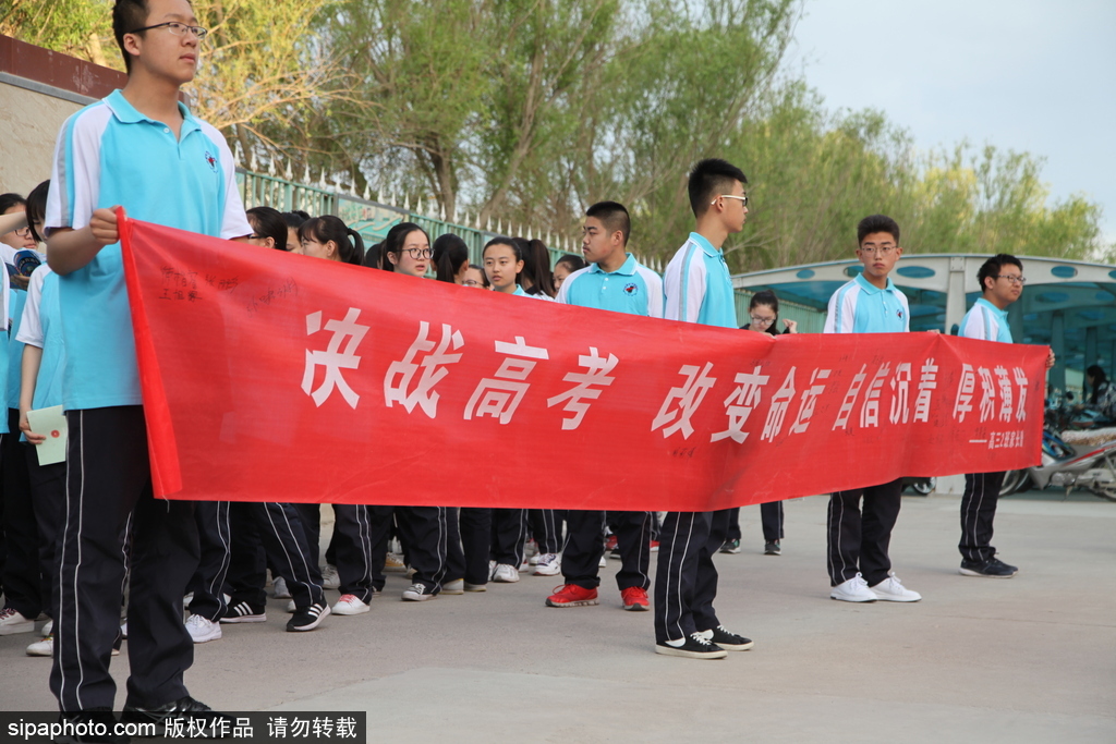 新疆哈密：高考第一日 低年級學(xué)生家長送考沿路壯行