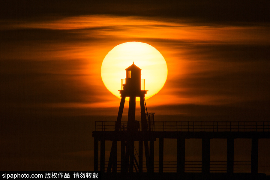 英國(guó)惠特比碼頭日出風(fēng)光 燈塔影影綽綽景色美