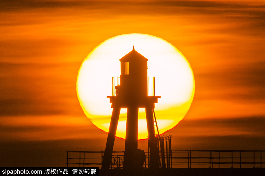 英國(guó)惠特比碼頭日出風(fēng)光 燈塔影影綽綽景色美